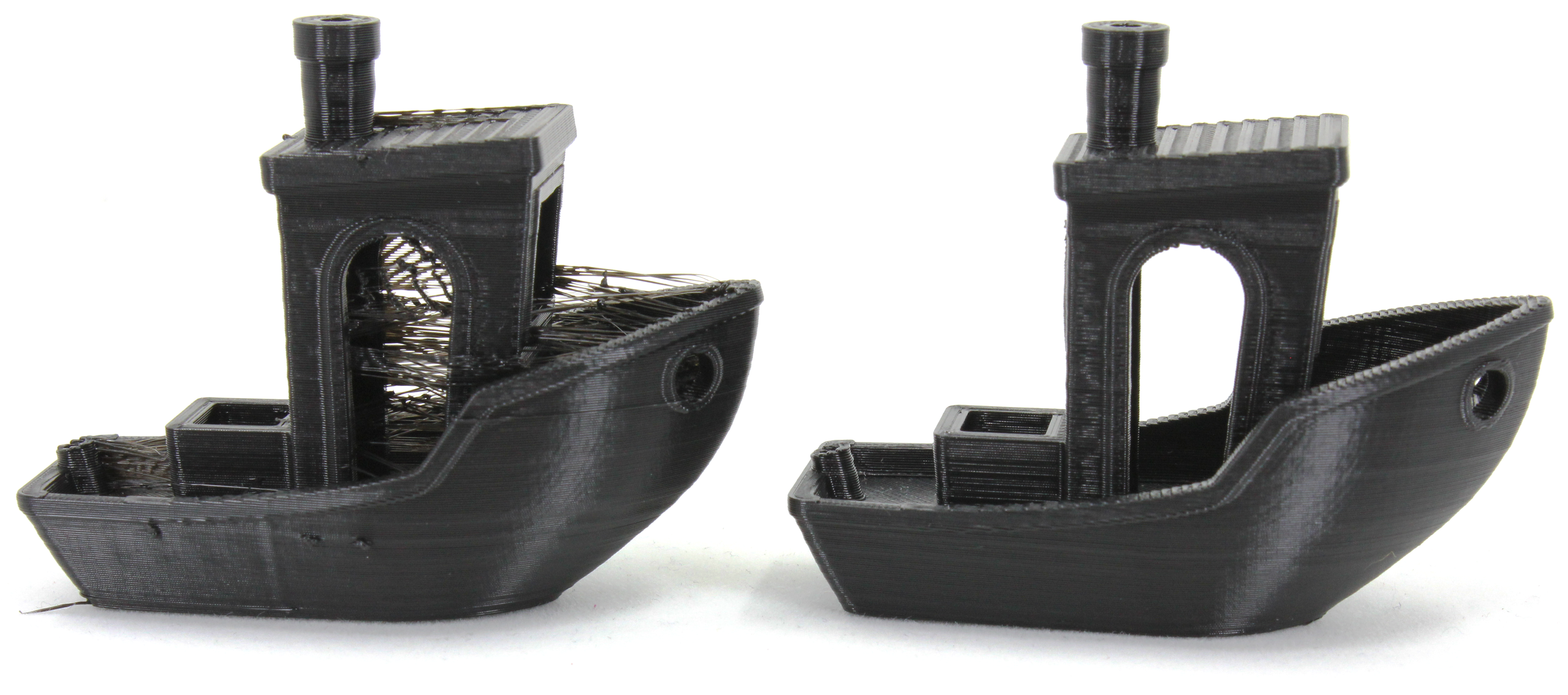 Very stringy 3D benchy next to a perfectly calibrated 3D benchy; both printed with black PETG filament.